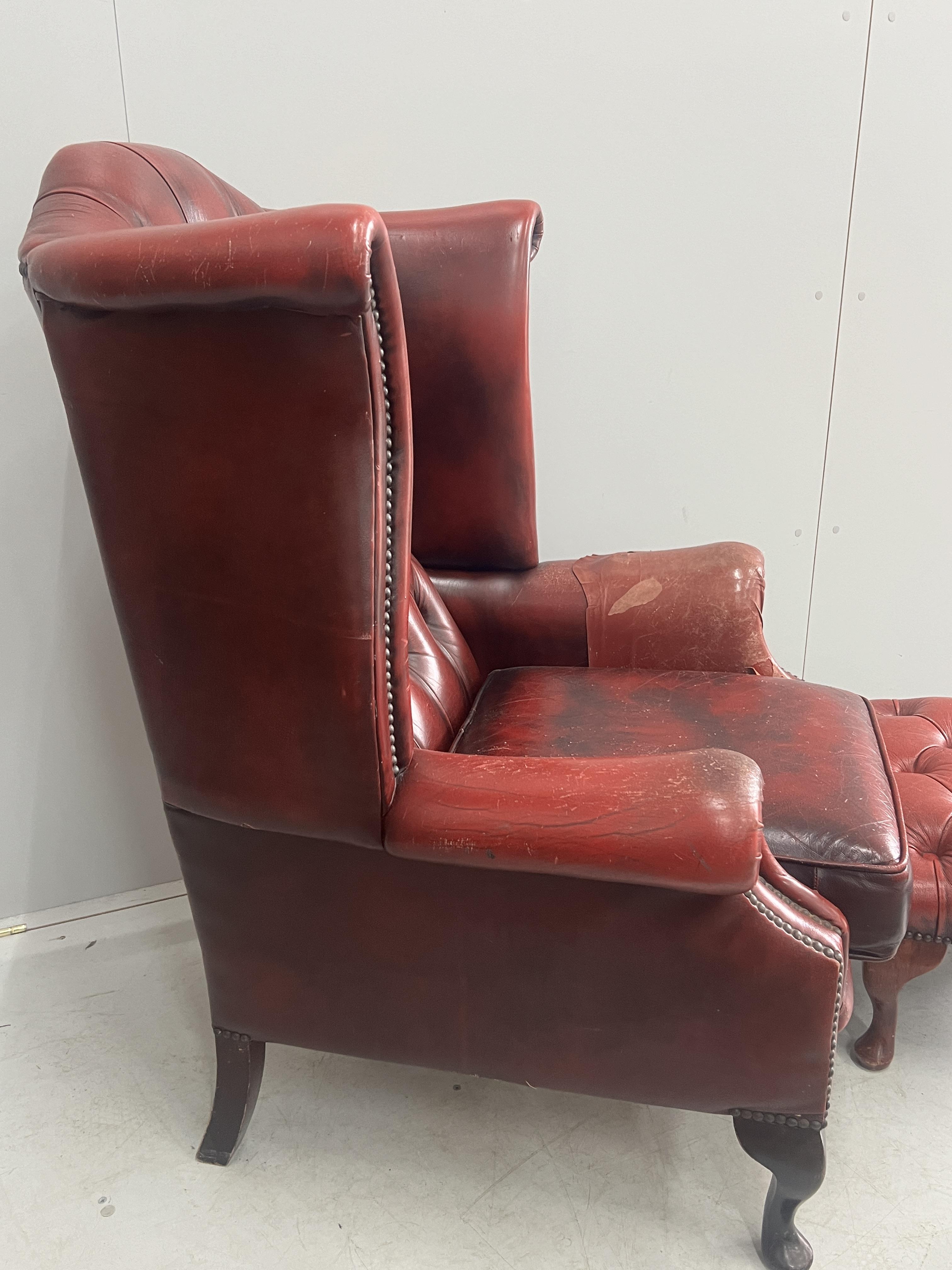 A Victorian style leather armchair, width 82cm, depth 80cm, height 110cm and footstool